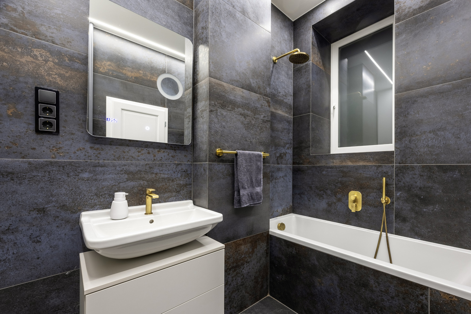 Bathroom with tub and gold fixtures