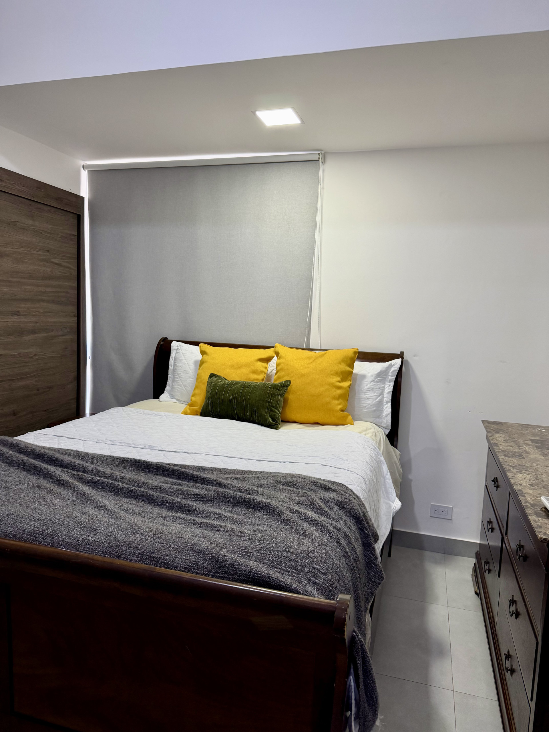 Bedroom with colorful pillows dresser