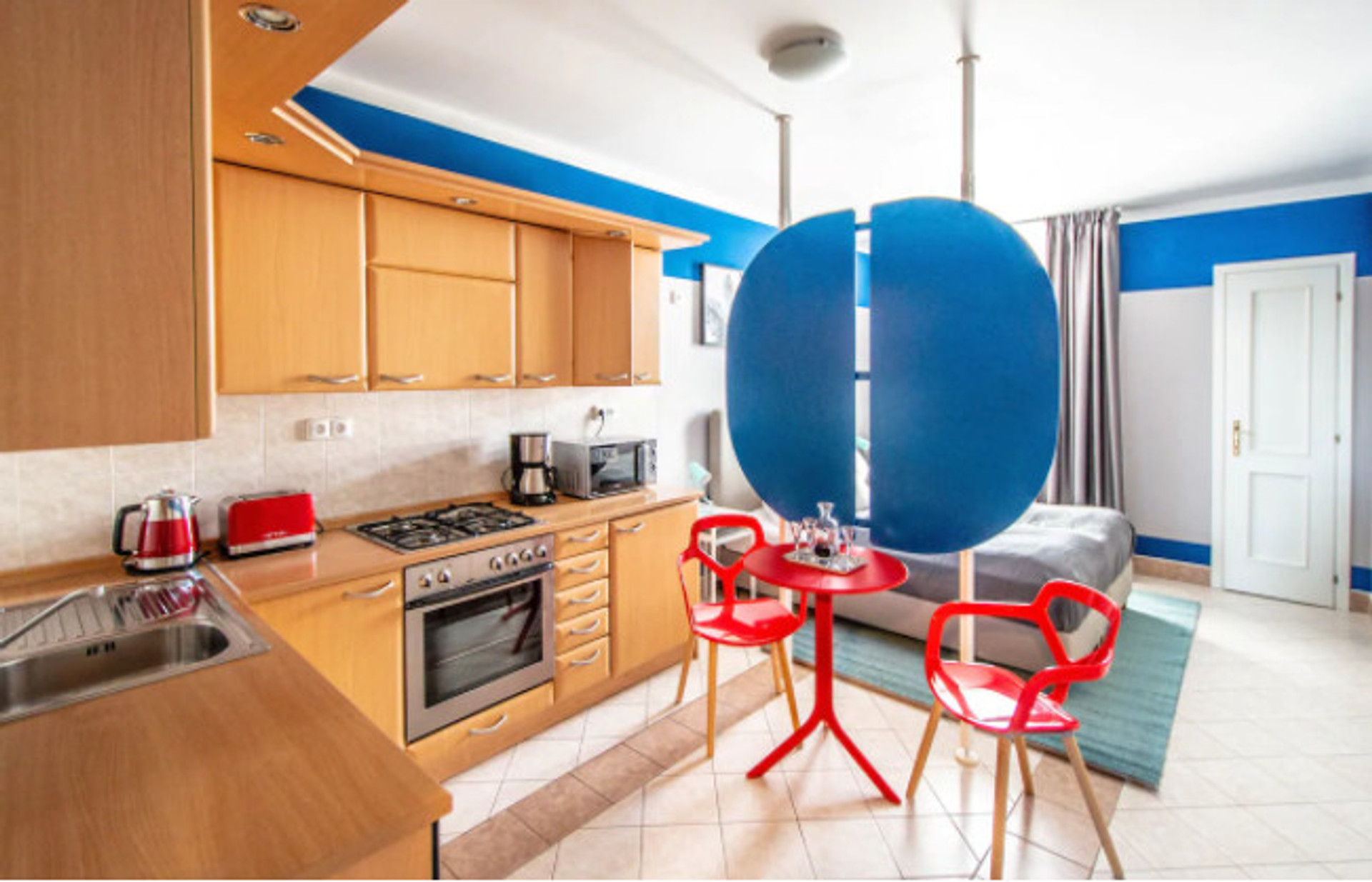 The 1st room is divided in 2 zones by design screen: fully equipped kitchen area and sleeping zone.