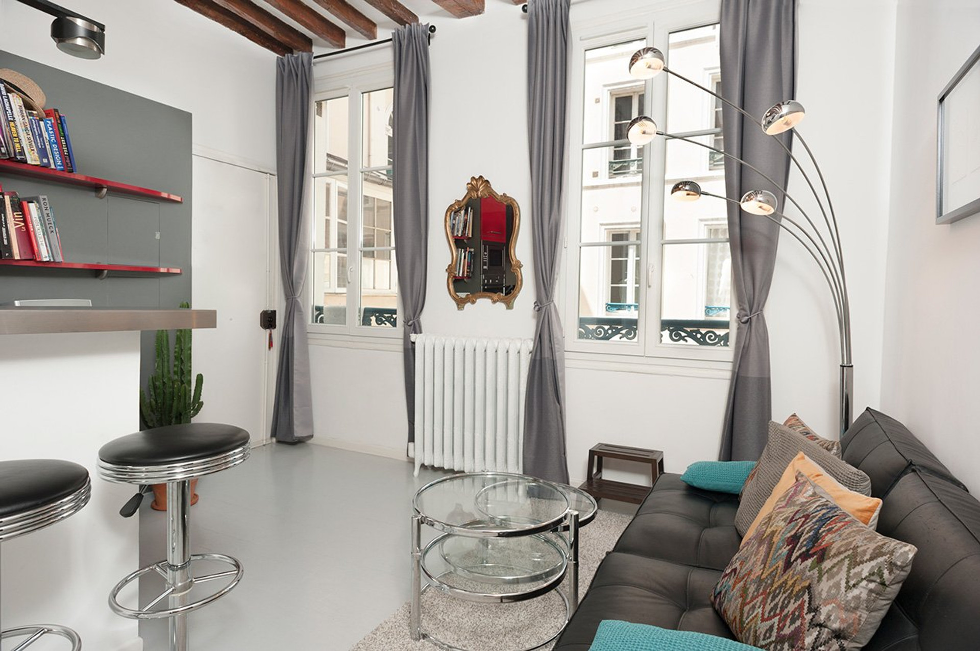 Bright living room featuring large windows and charming exposed beams.