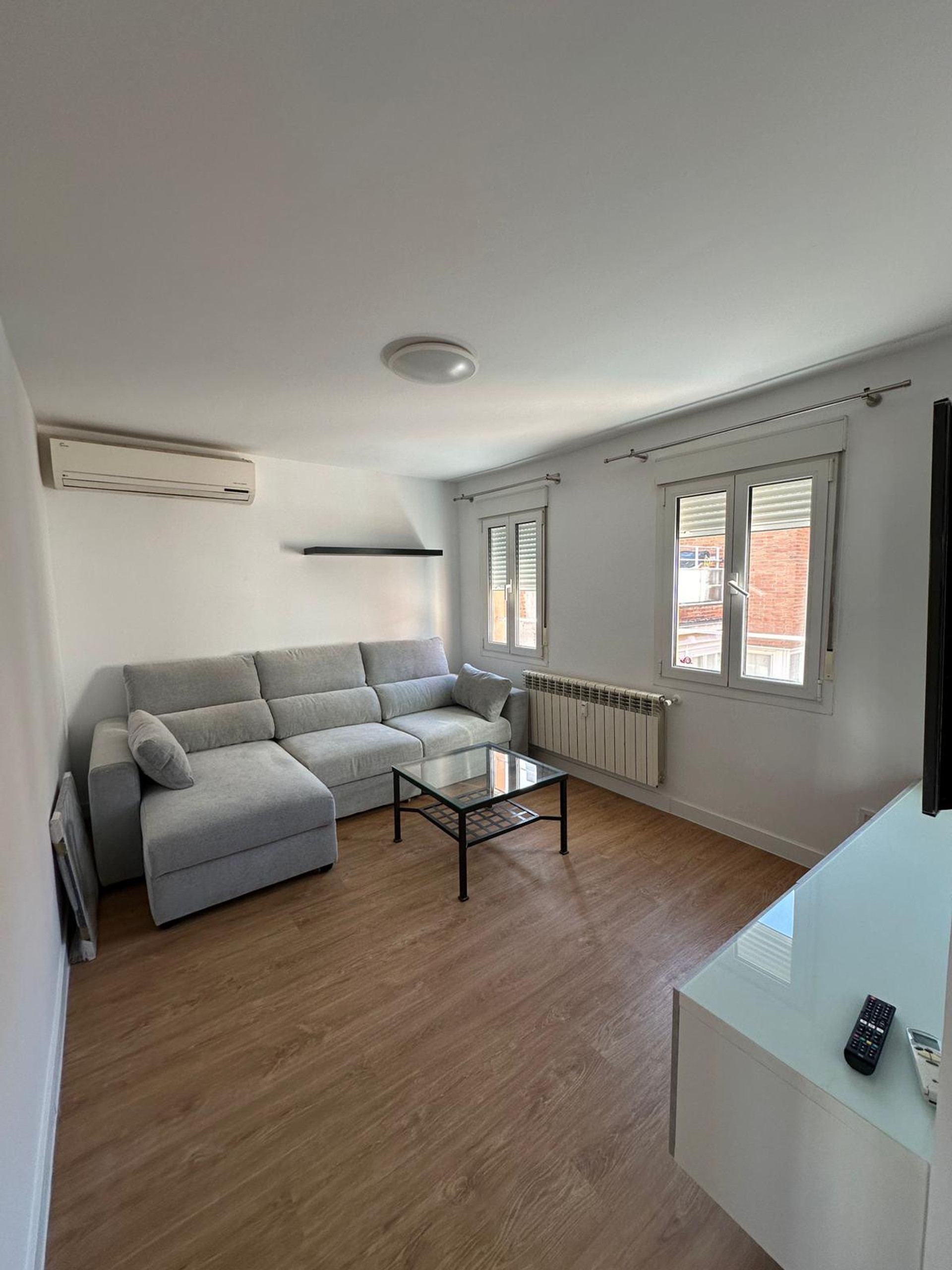 Salón con sofá cama. Las ventanas dan al patio comunitario