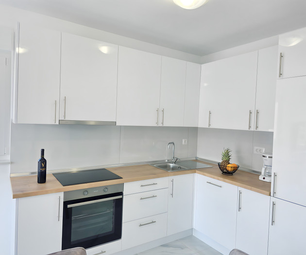 Modern white kitchen with wooden counters