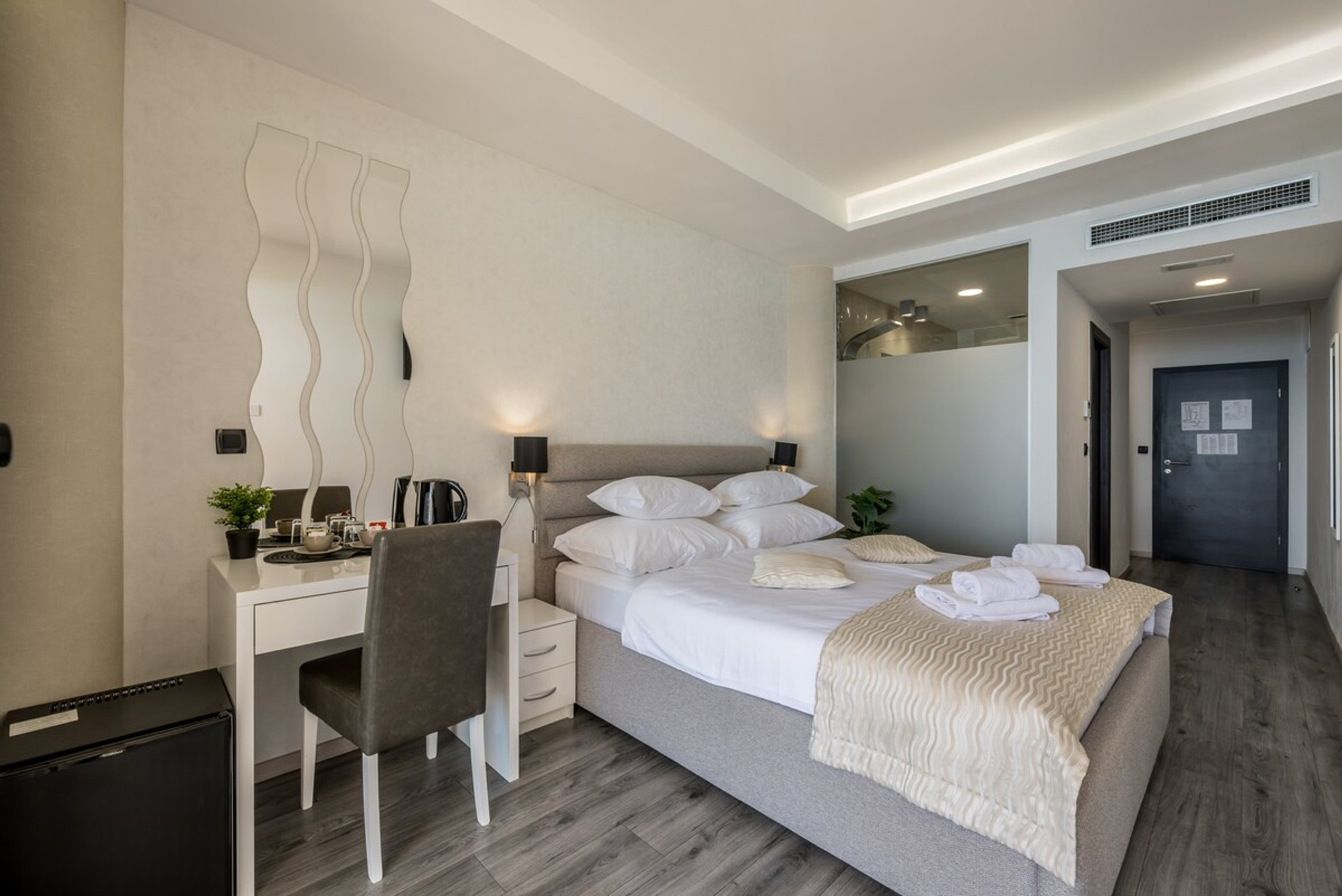 View of the full room with a working desk, seating area, and a queen-size bed.