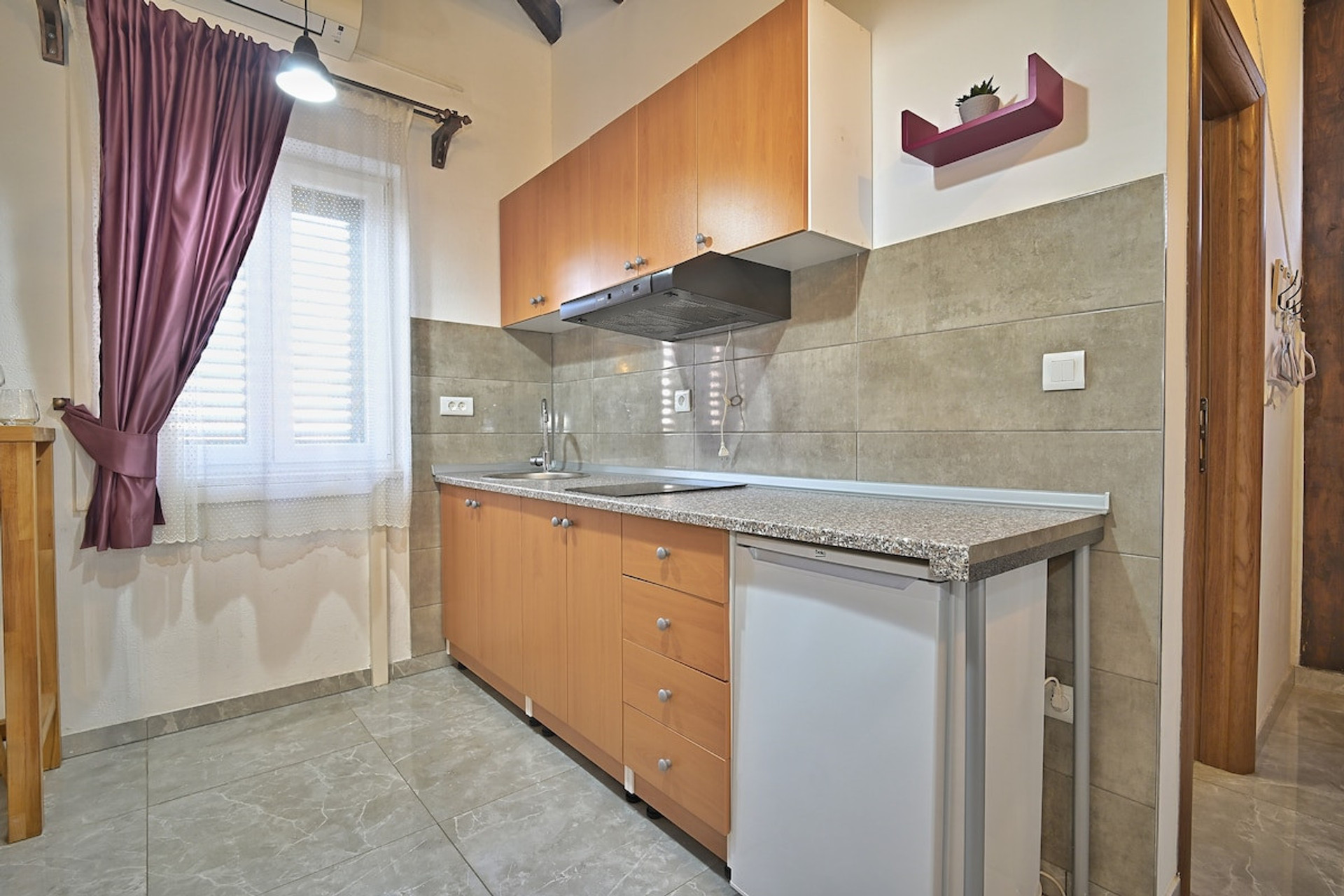 Kitchenette with small fridge, stove, and amenities for making a meal.