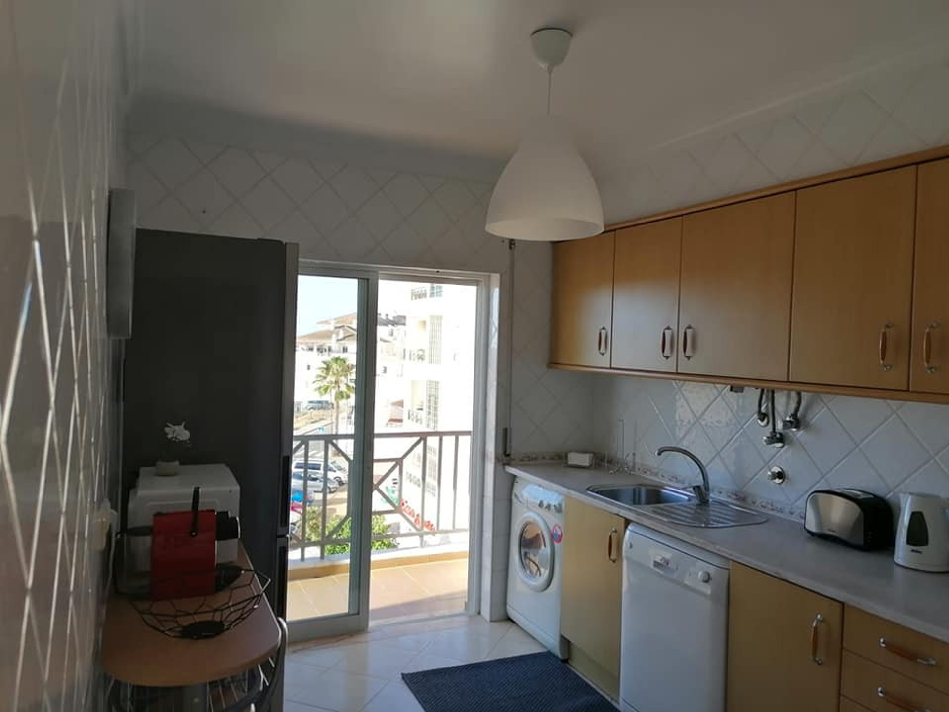 Kitchen with balcony access and appliances