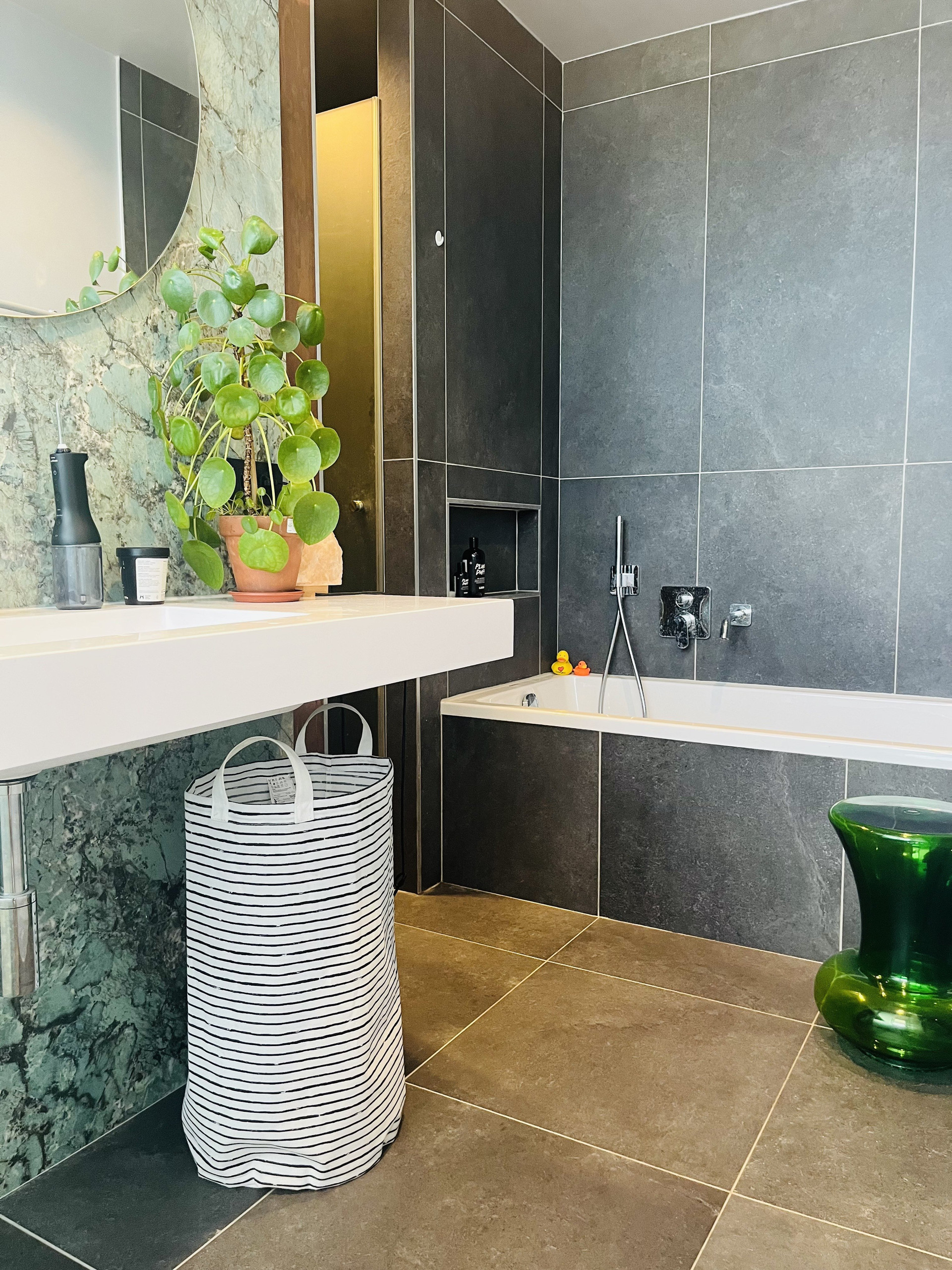 Dark tiled bathroom with bathtub and shower