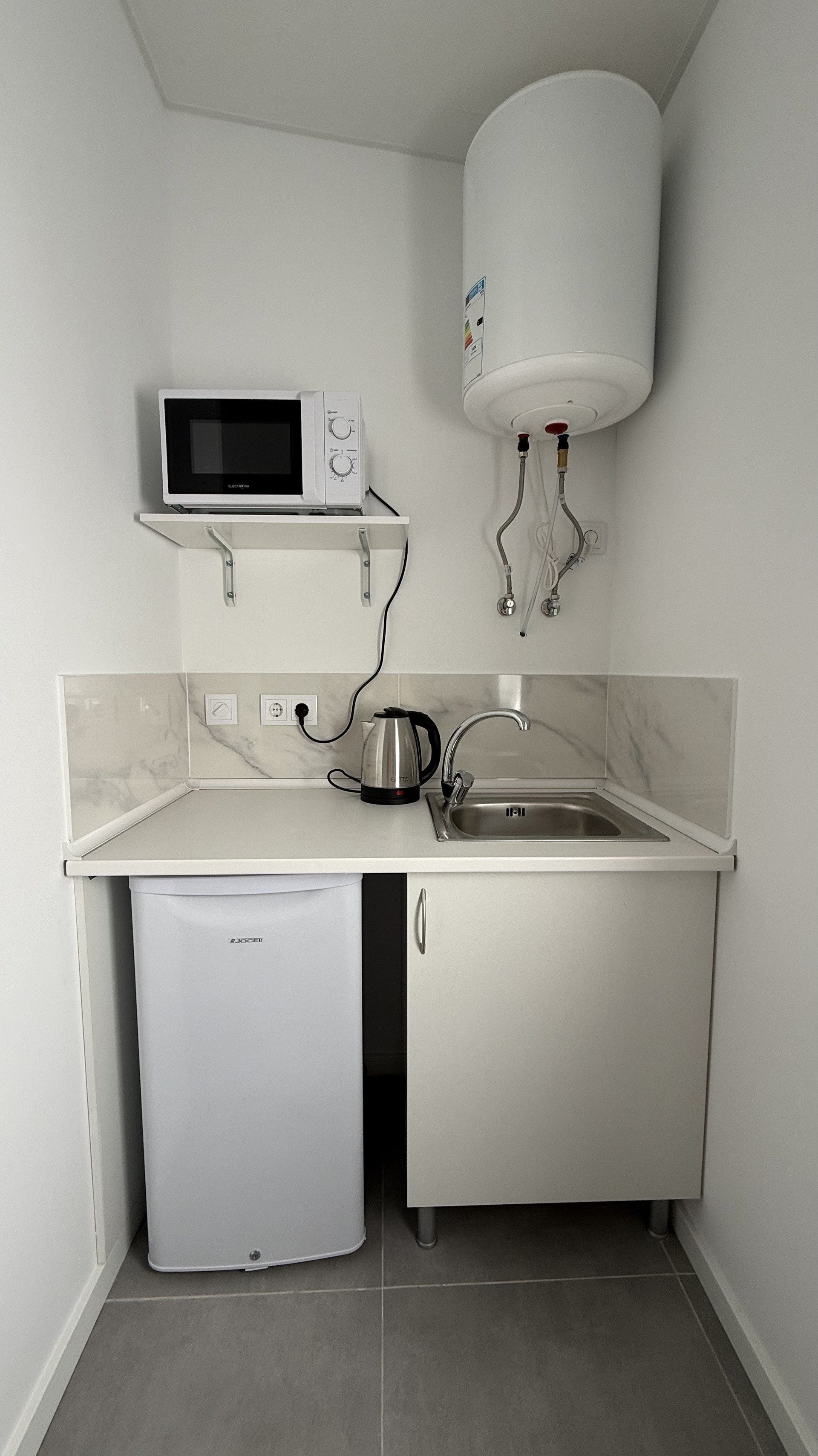 Compact kitchenette with sink and fridge