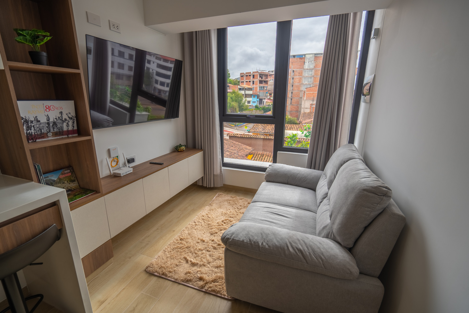 A room with a television, a comfortable sofa for you to enjoy