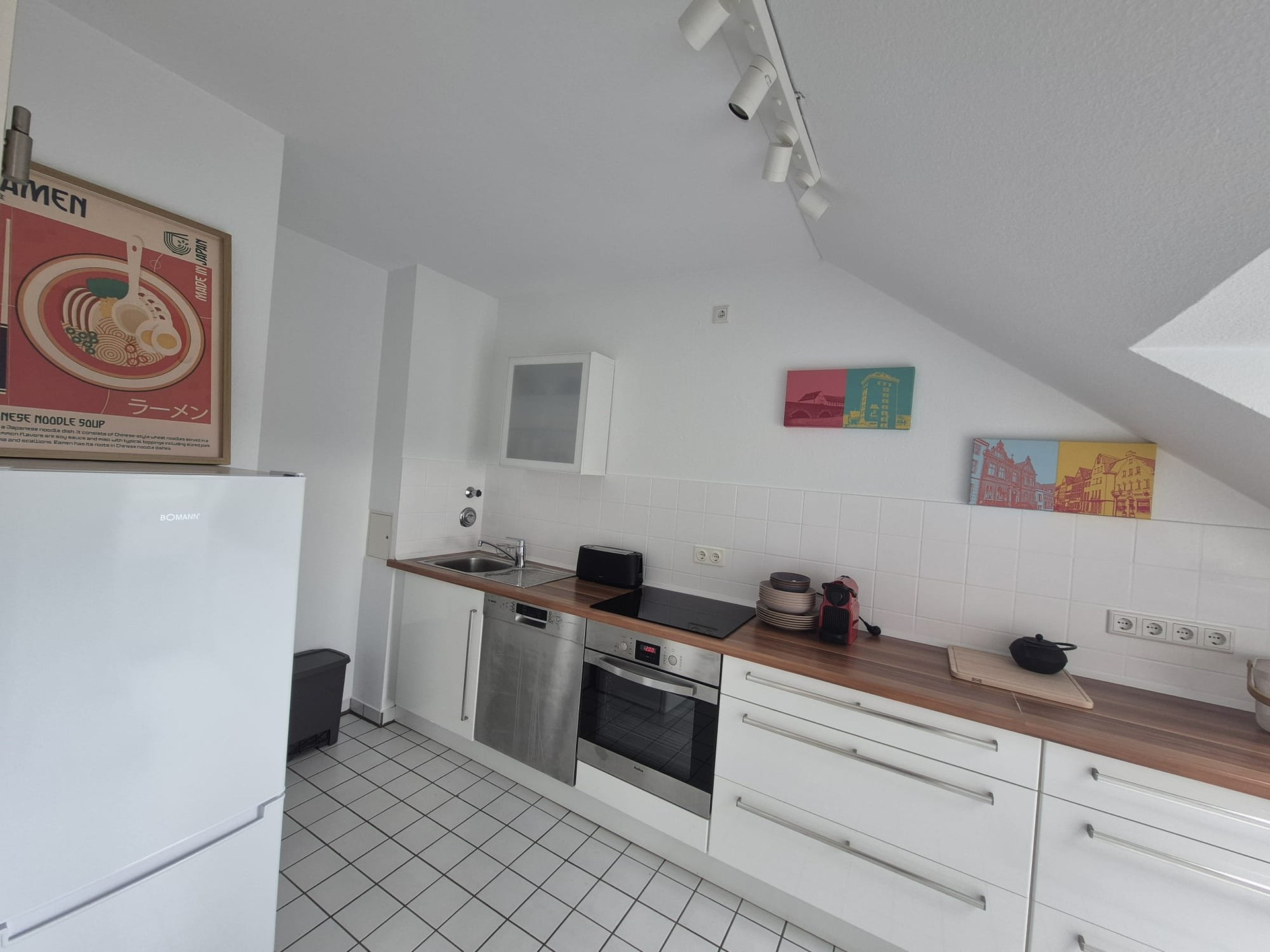 White kitchen with appliances and art