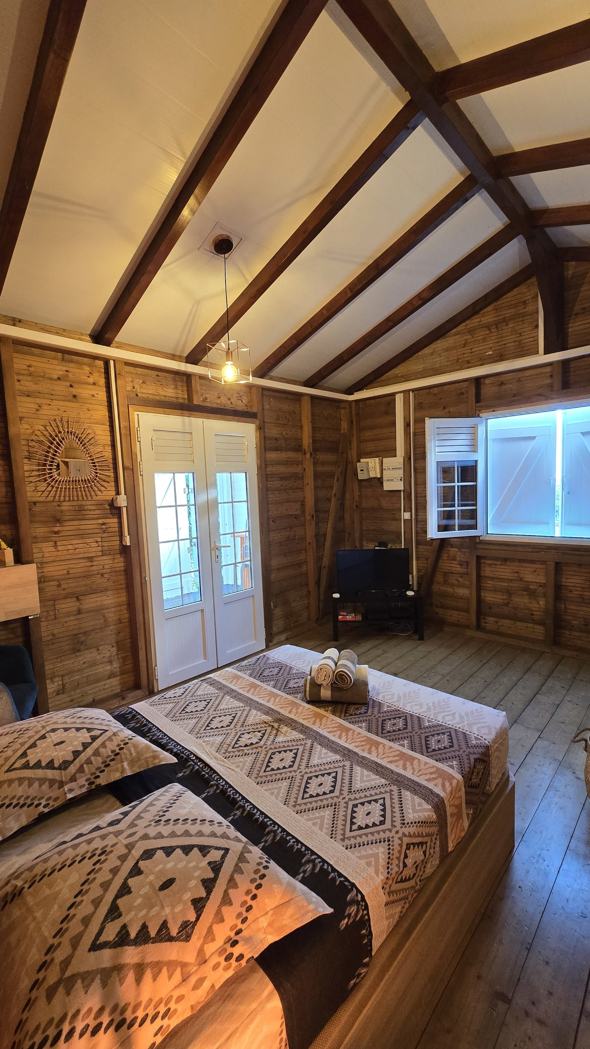 Bright wooden bedroom with natural light and simple, functional layout