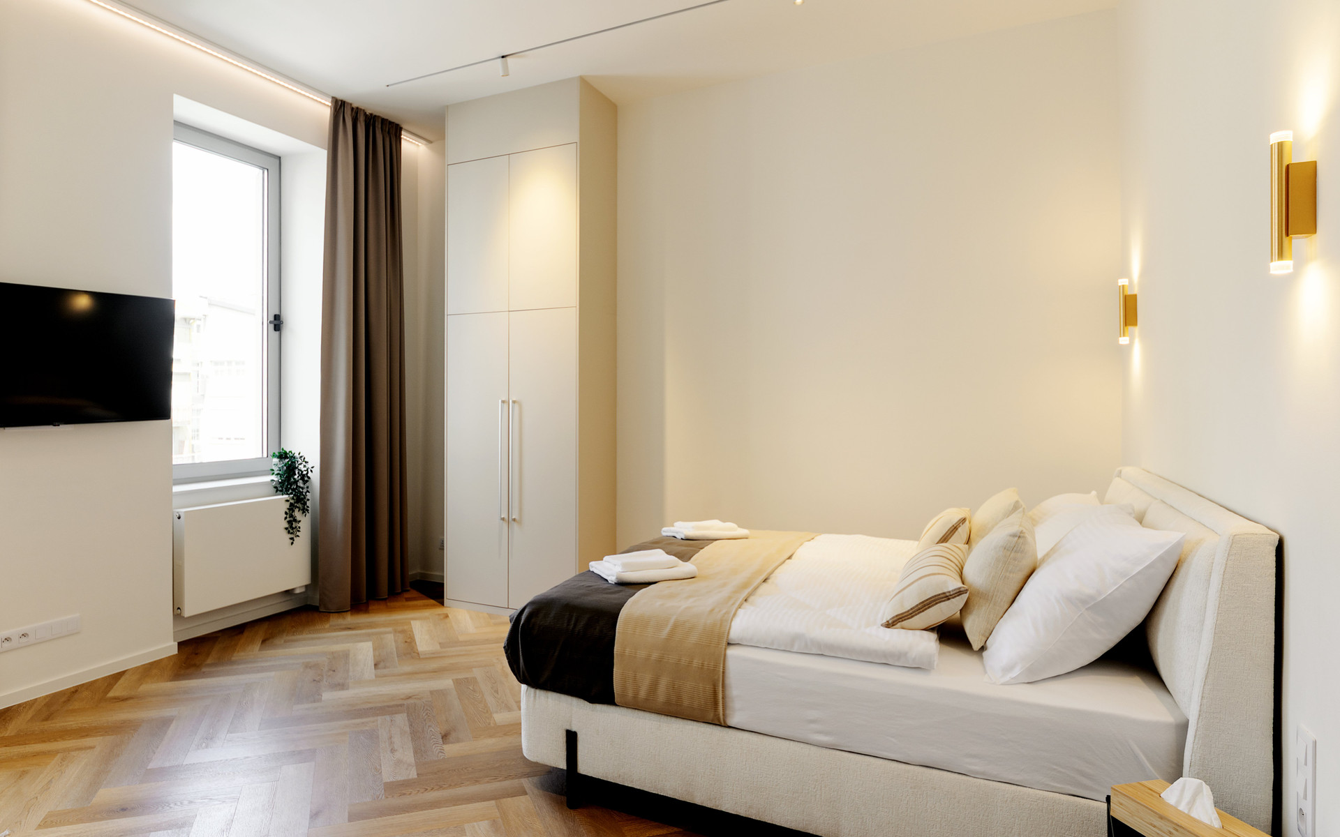 Bright bedroom with wardrobe and TV