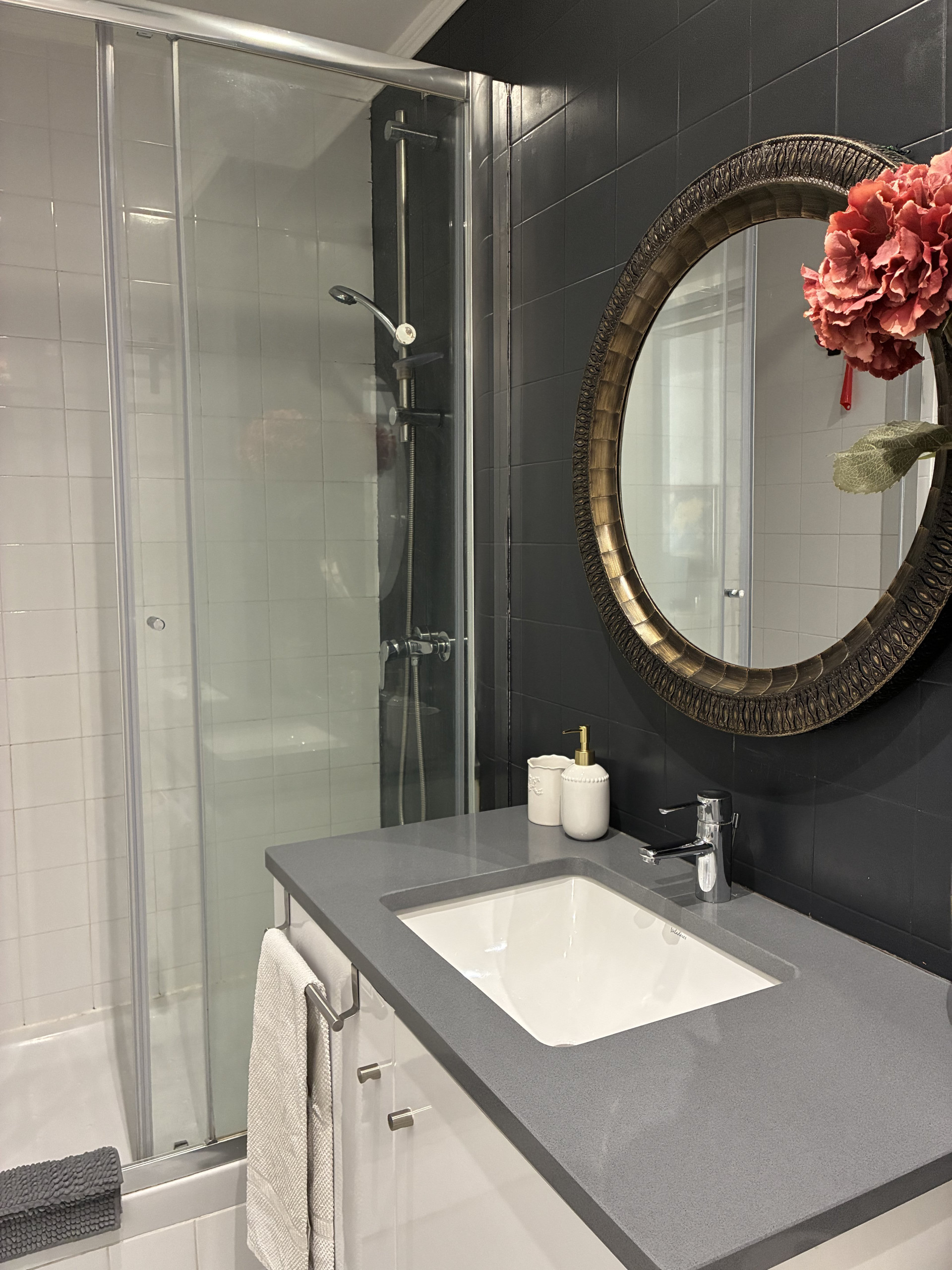 Bathroom with shower and round mirror