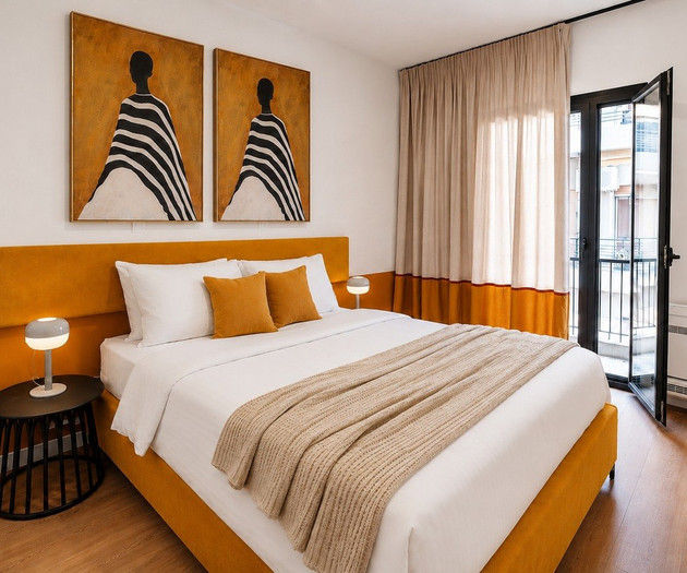 Bedroom with orange headboard and balcony