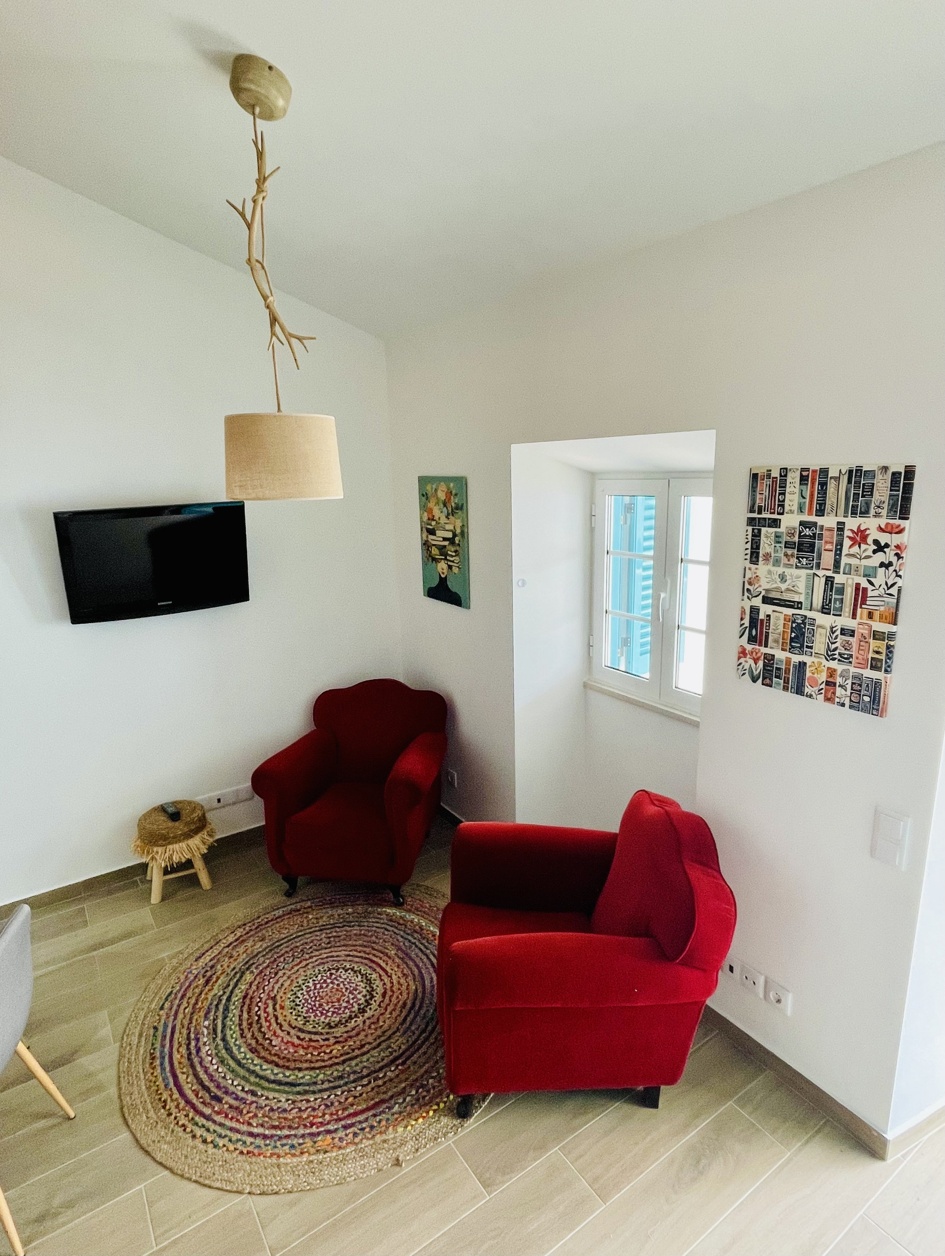 Living area with red armchairs TV