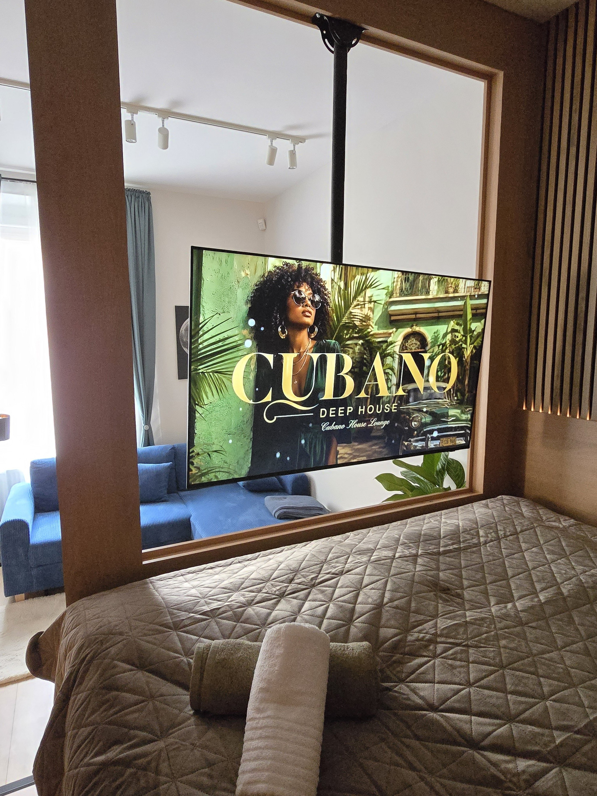 Bed and TV overlooking blue sofa
