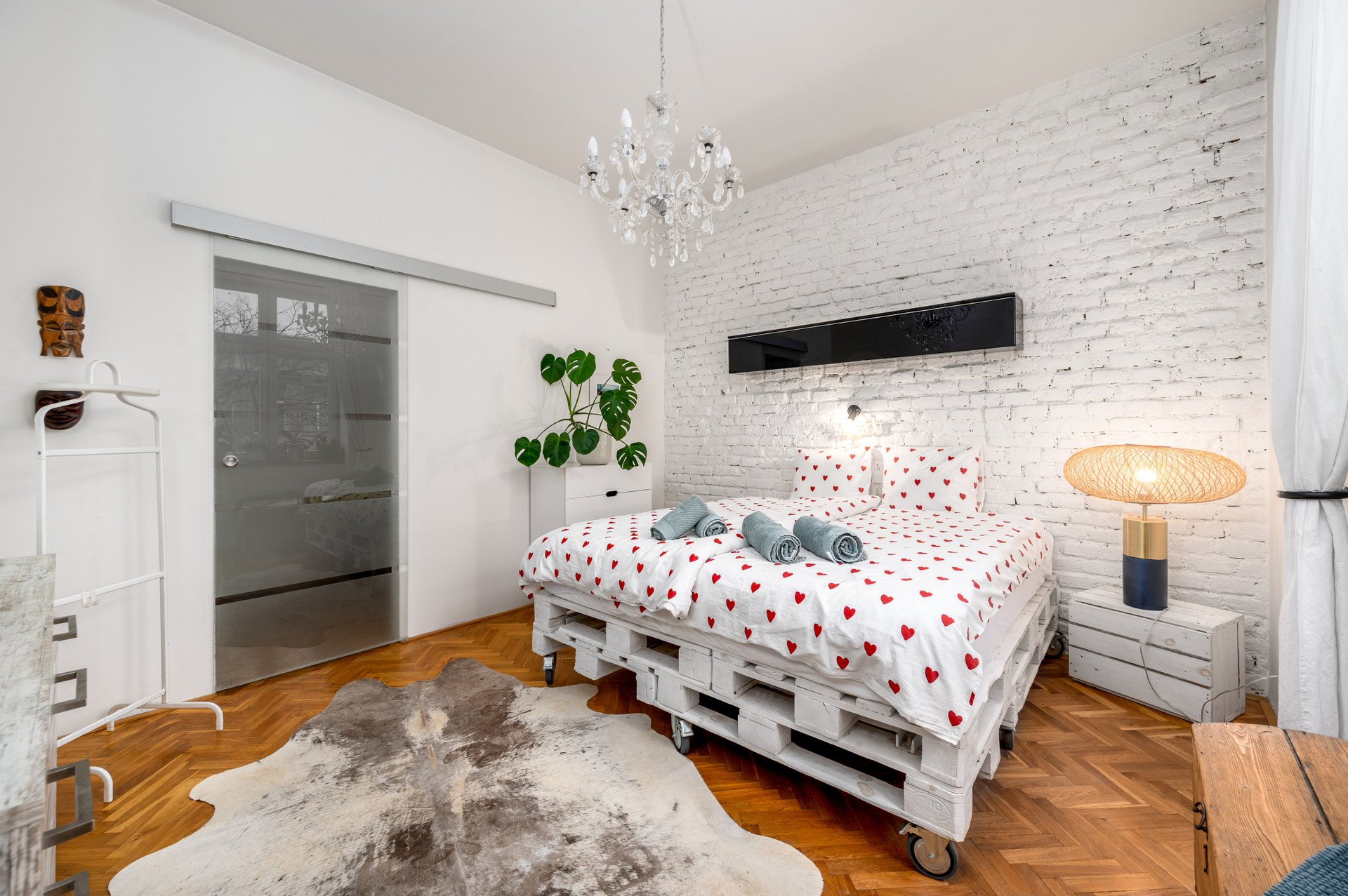 Bedroom with pallet bed brick wall