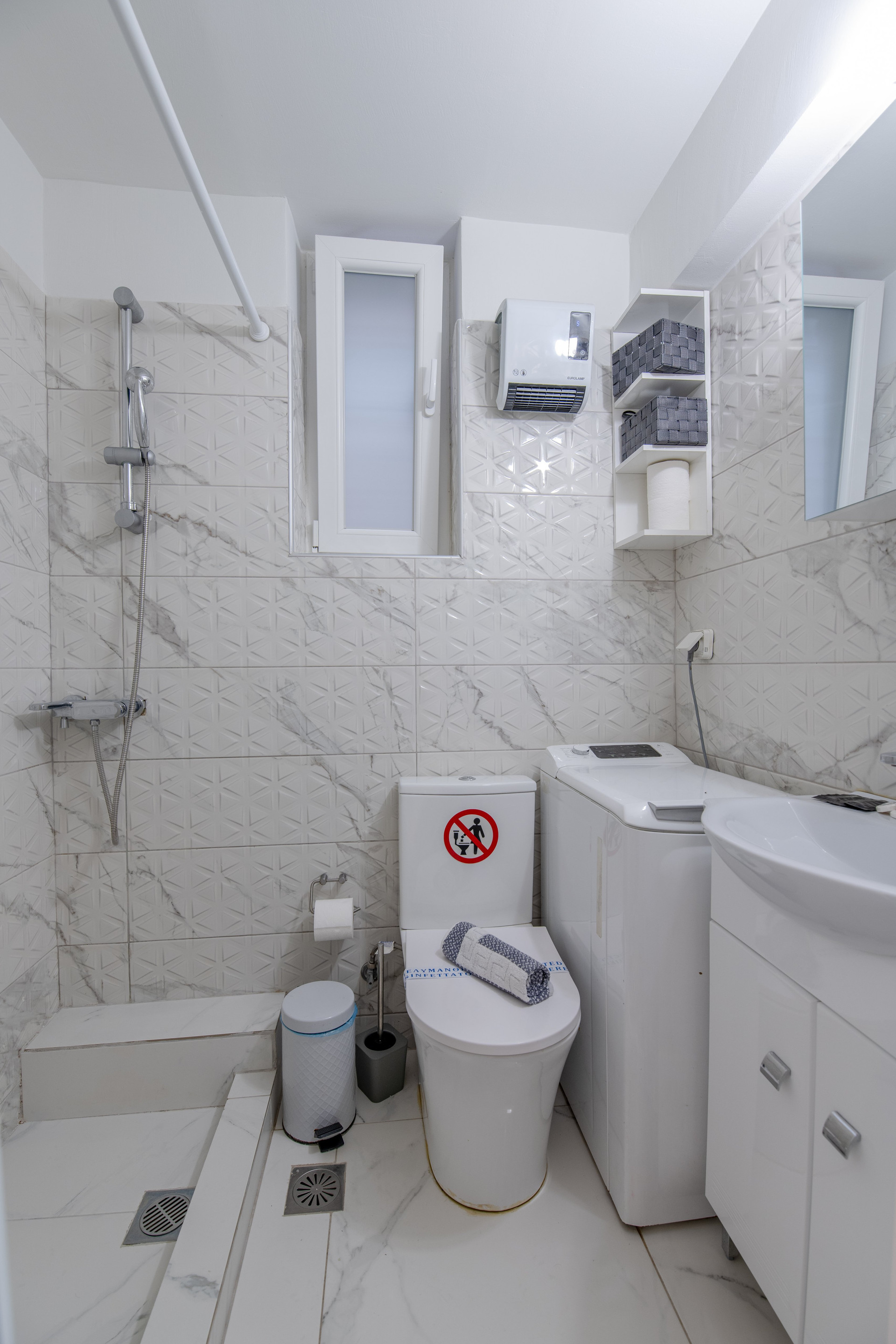 White bathroom with shower and washer