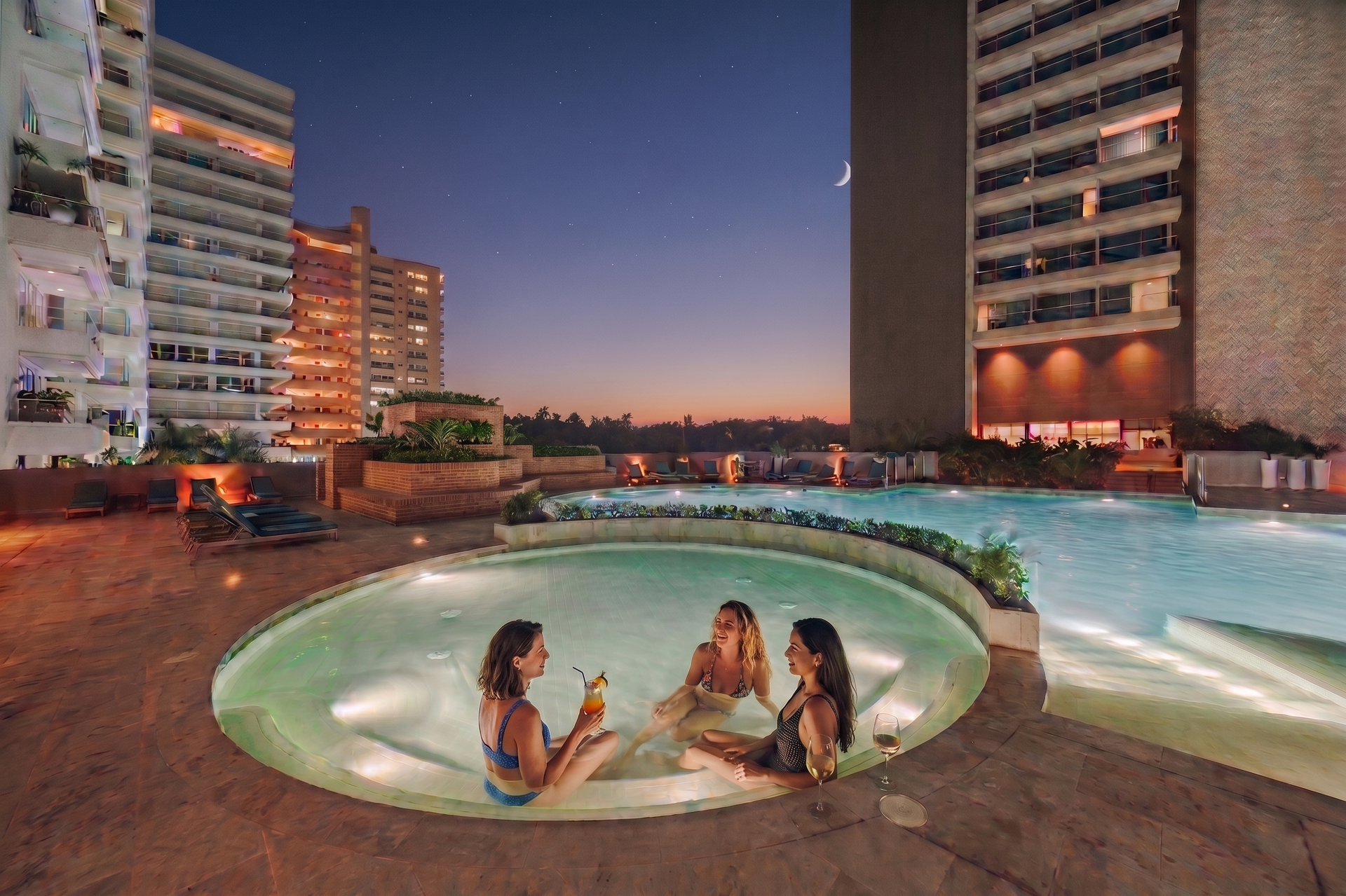Piscina iluminada al atardecer con ambiente exclusivo, ideal para relajarte después de playa. Disfruta de las vistas abiertas, zonas comunes premium y una experiencia única en Santa Marta.