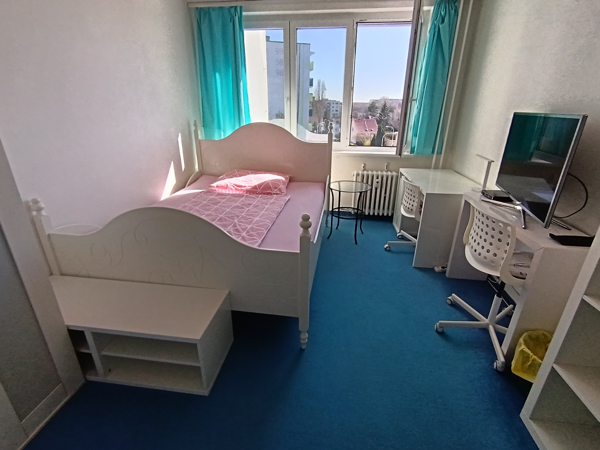 Bright bedroom with desk and TV