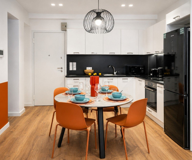 Kitchen and dining area with orange chairs