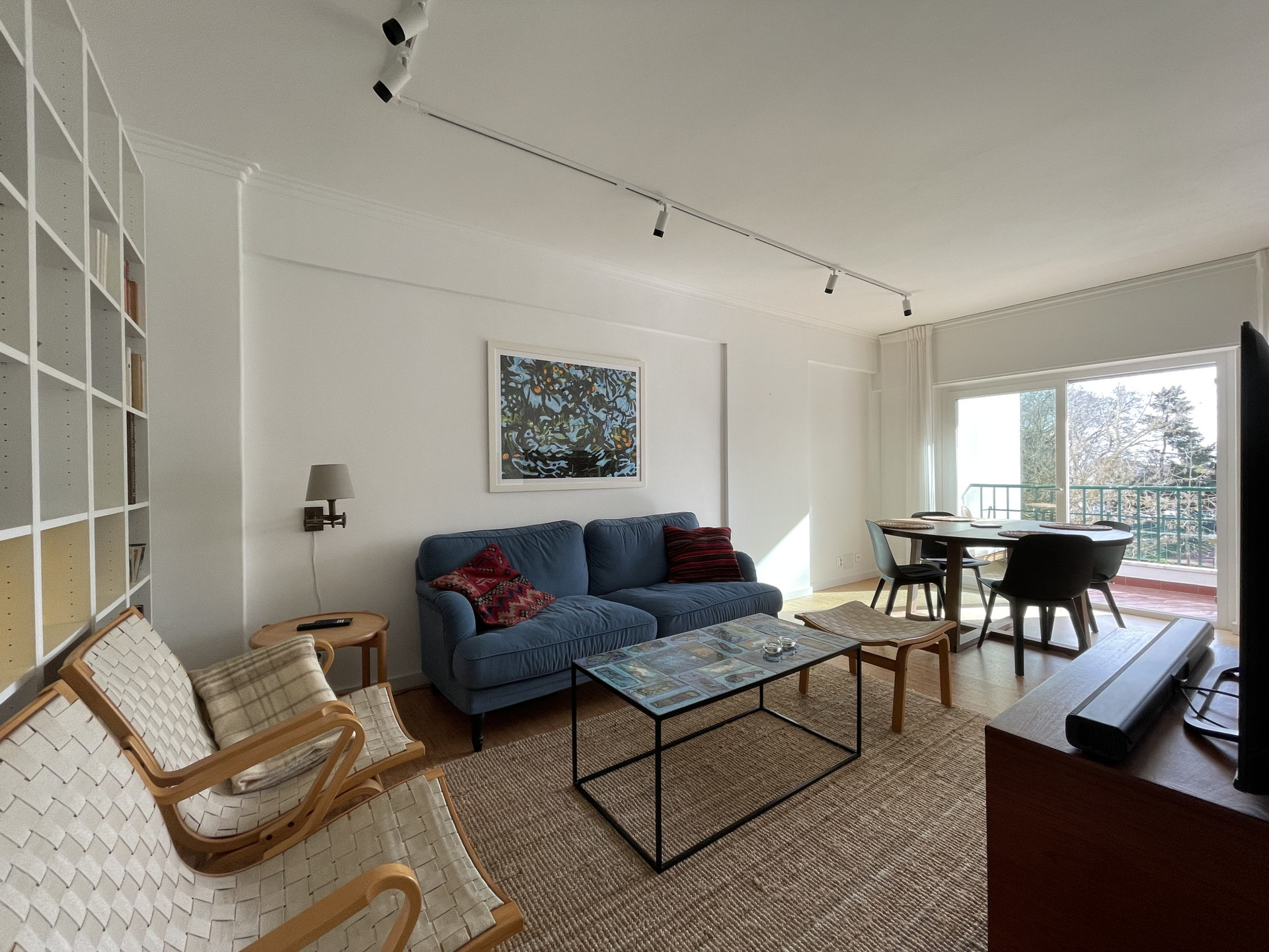 Sunny south-facing living room with mid-century Scandinavian and Portuguese furniture and unique decorative items, smart-tv and sound system.