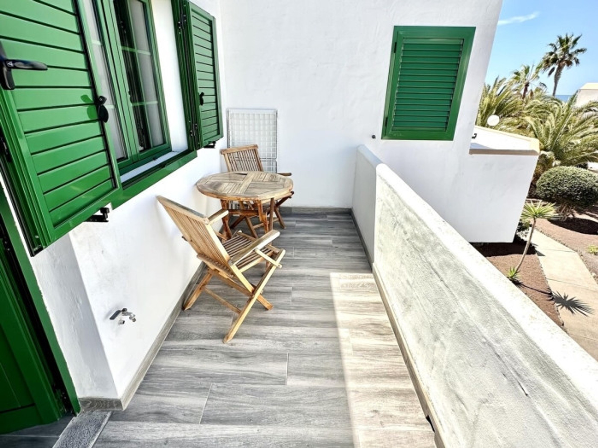 Balcony with wooden table chairs