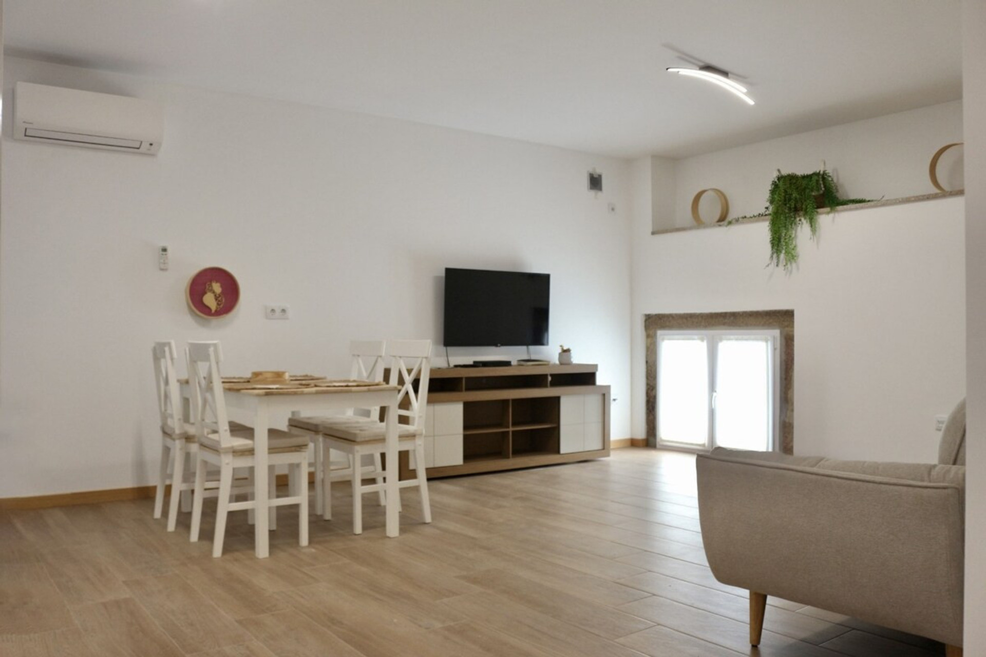 Dinning room and living room with AC and smart TV.
