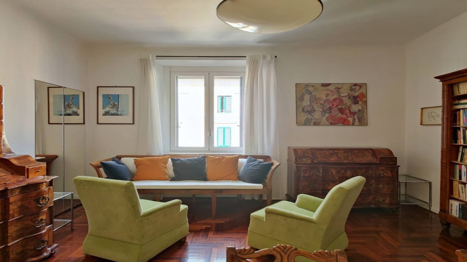 A living room with a story. Antique walnut furniture, original artwork, books