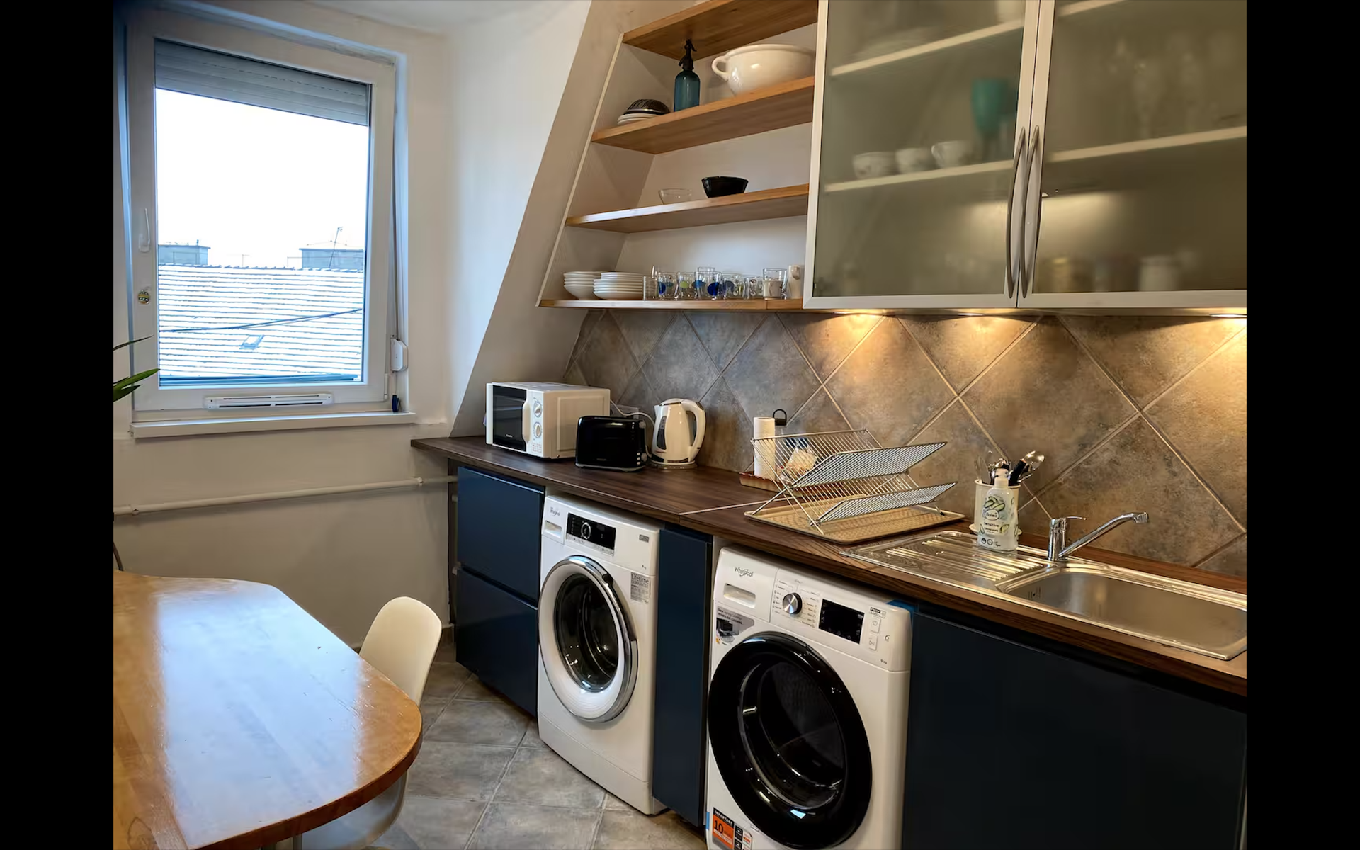 Kitchen with kettler, microwave, toaster, washing machine and dryer 