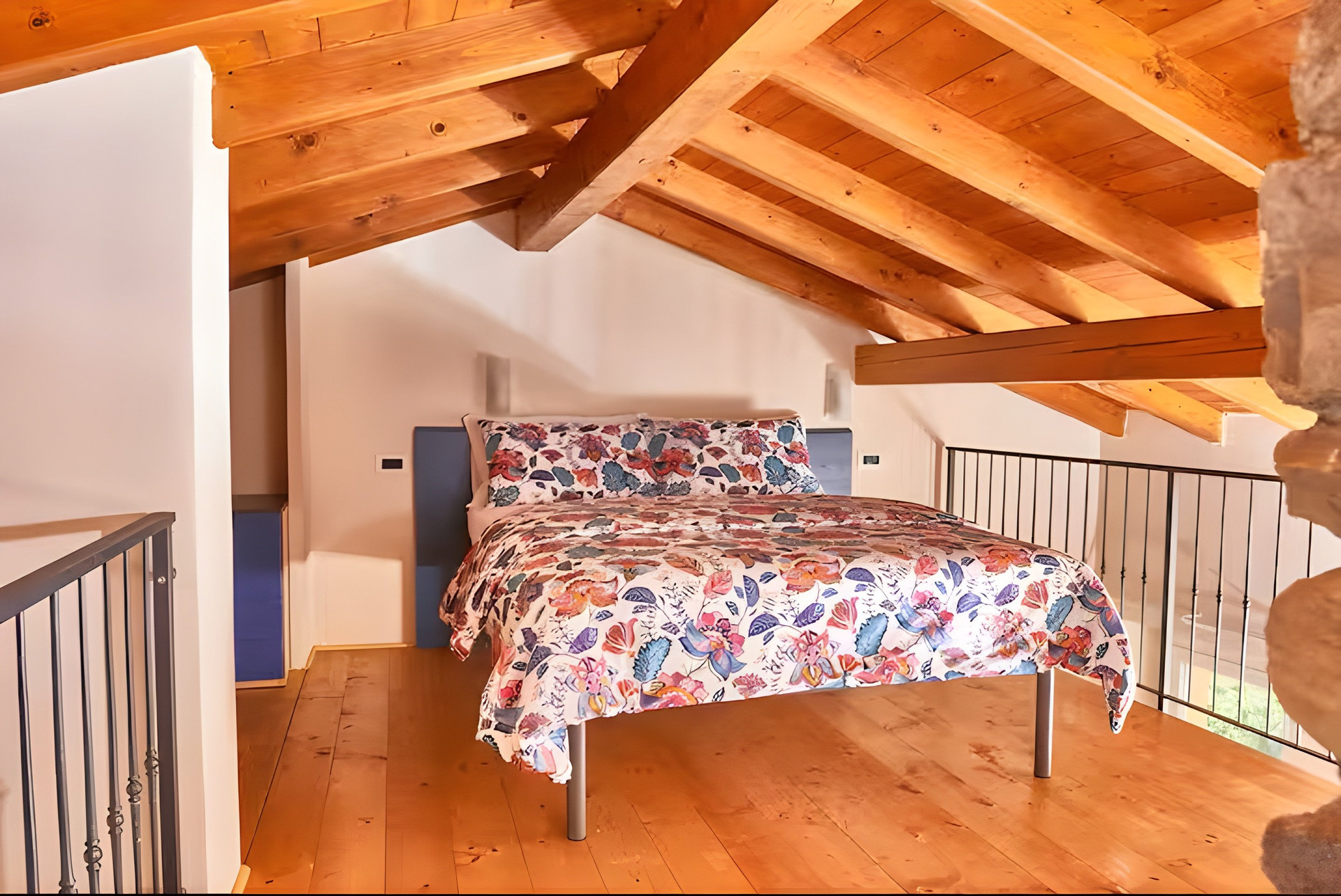 Double bed under wooden beams