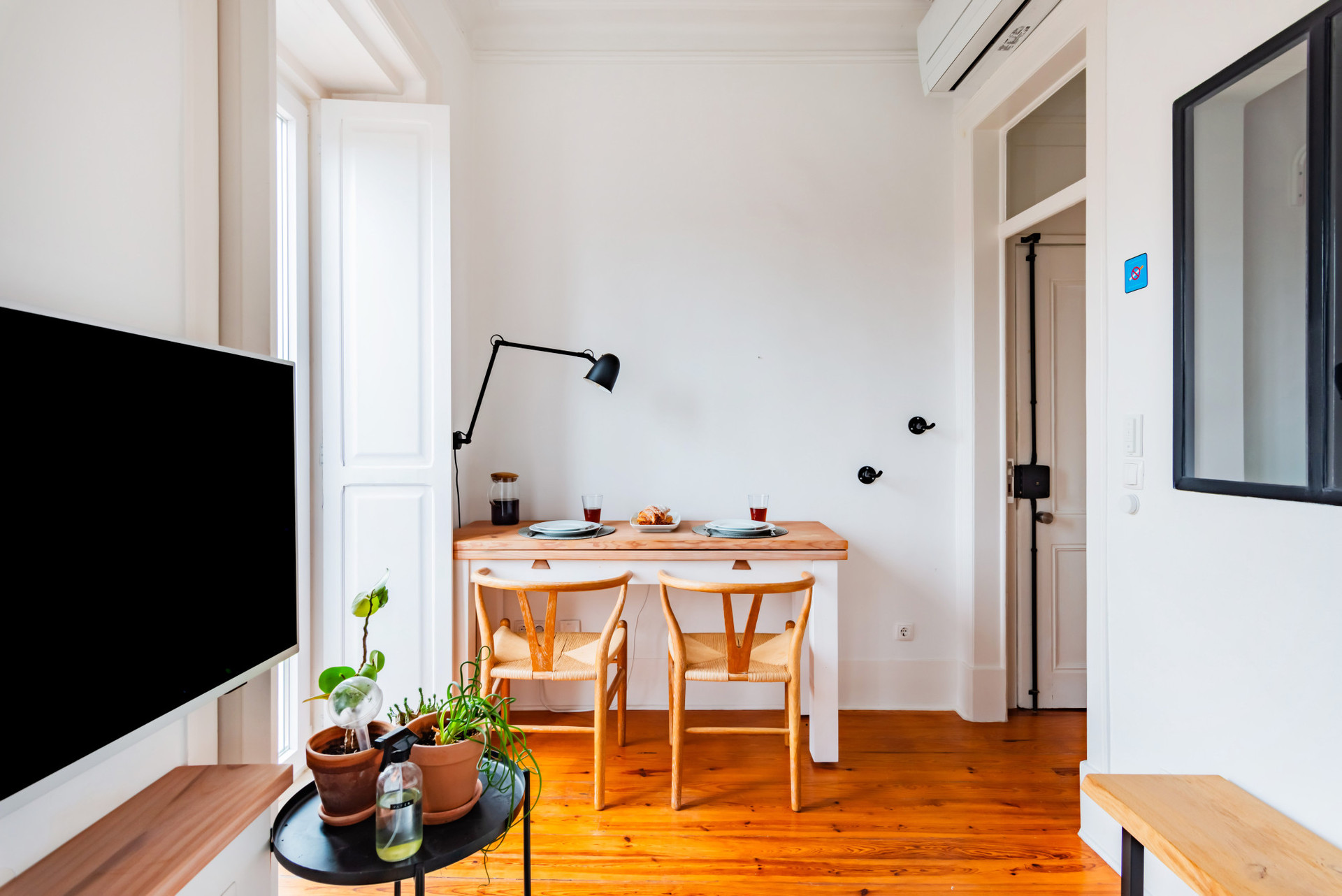 Living Room with a comfortable sofa, TV, Air Conditioning, Dining table for 2 and access to the balcony.