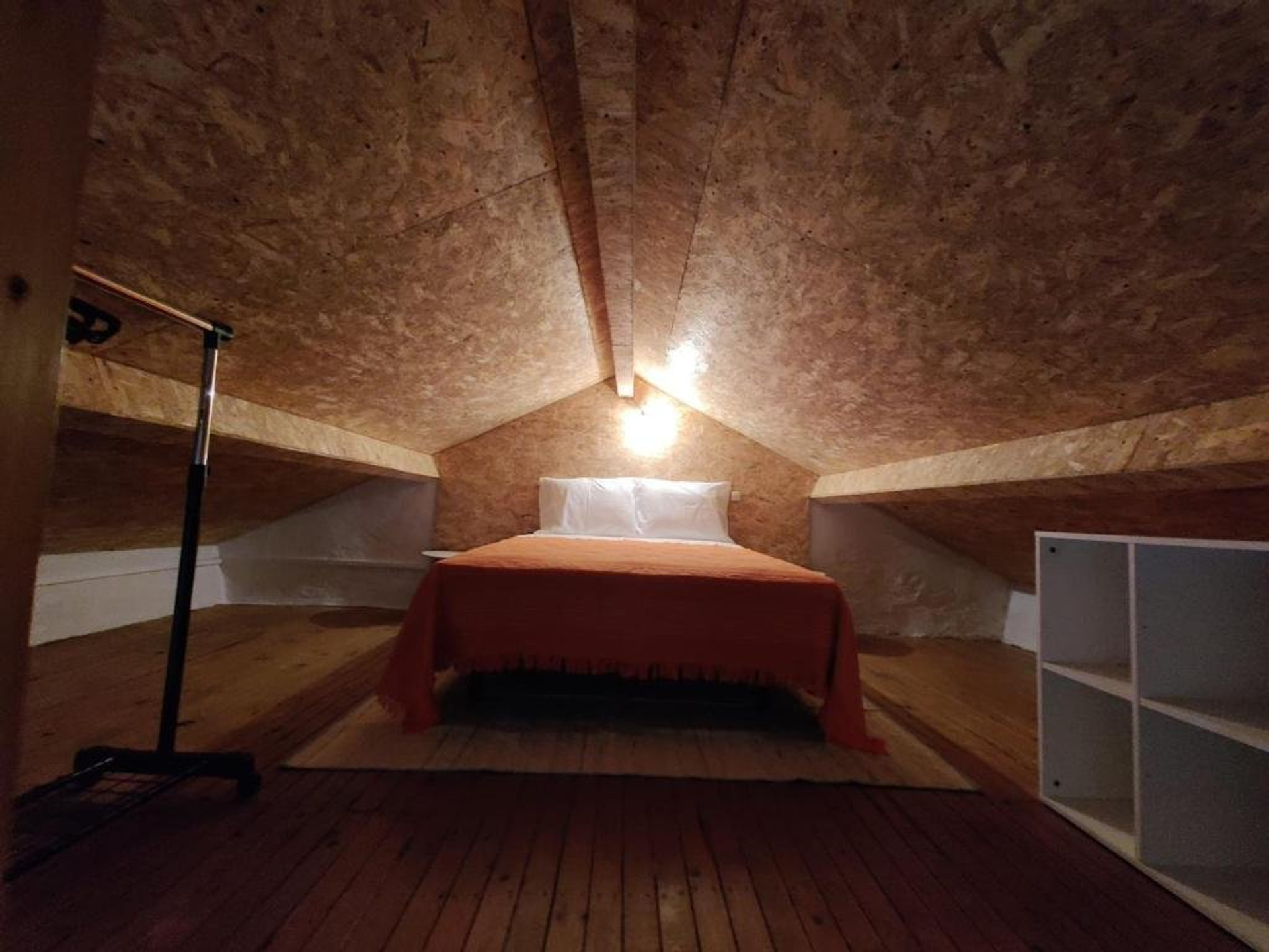 Attic bedroom with orange throw