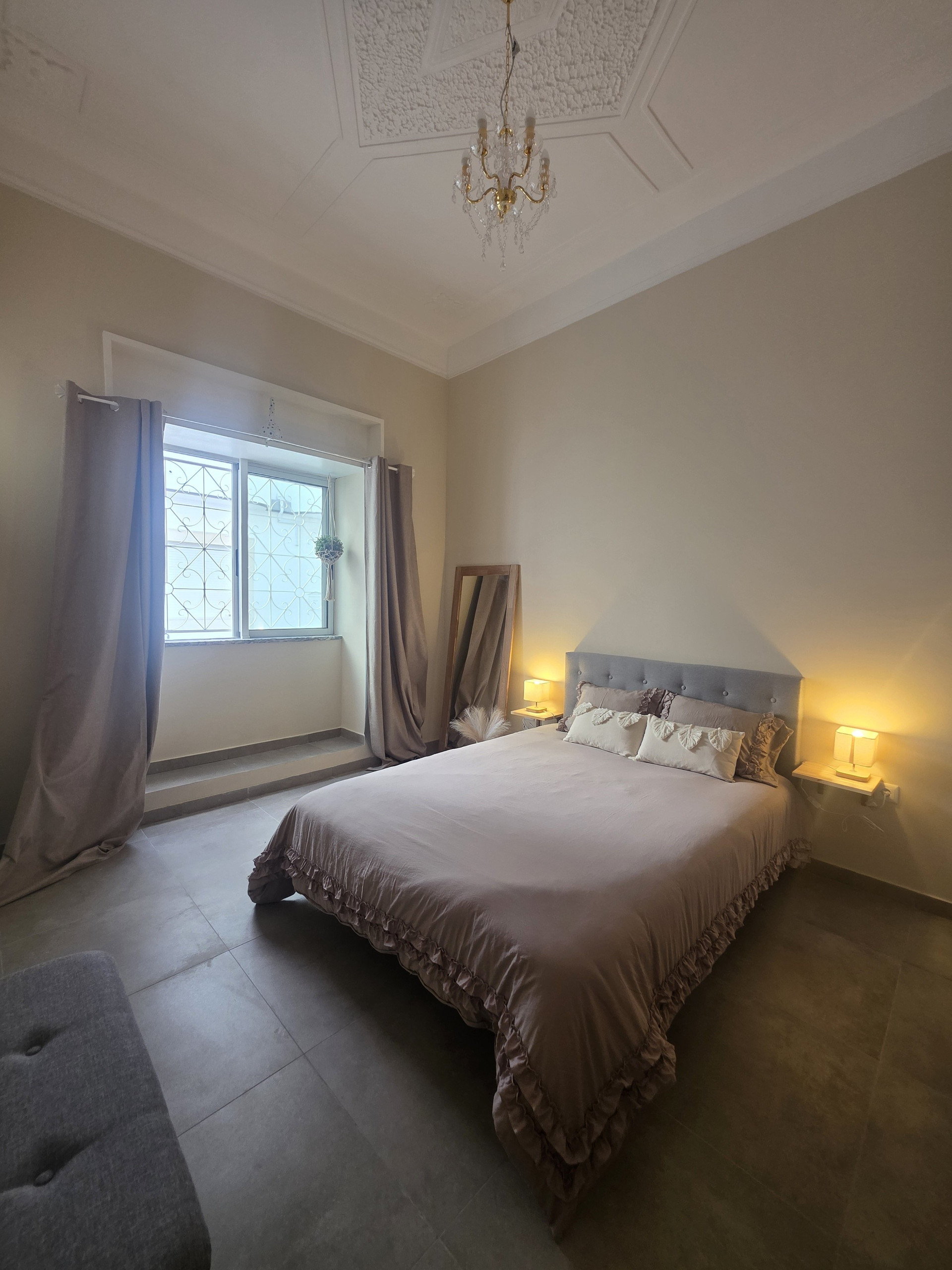 Elegant bedroom with chandelier and window