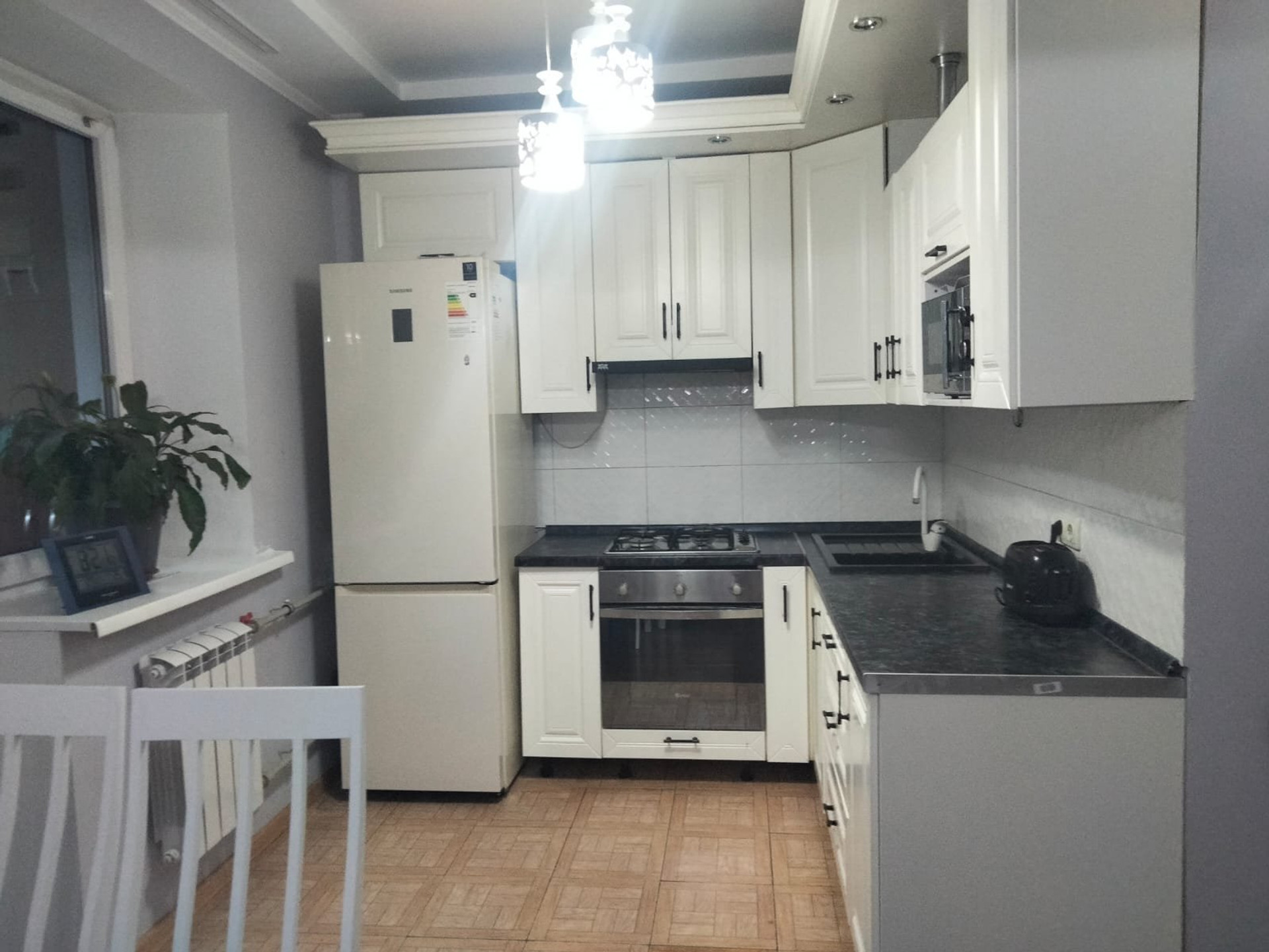 Bright fully equipped kitchen with appliances: oven, stove, fridge, dishwasher and plenty of storage space.
